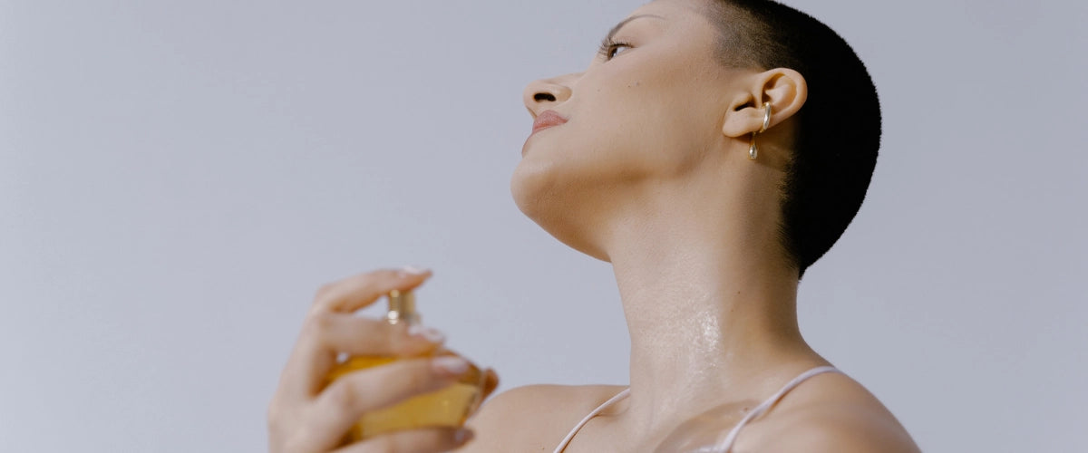Mujer echandose perfume en el cuello